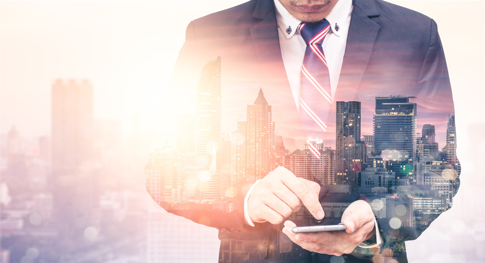 Man on Smartphone Blending with Cityscape